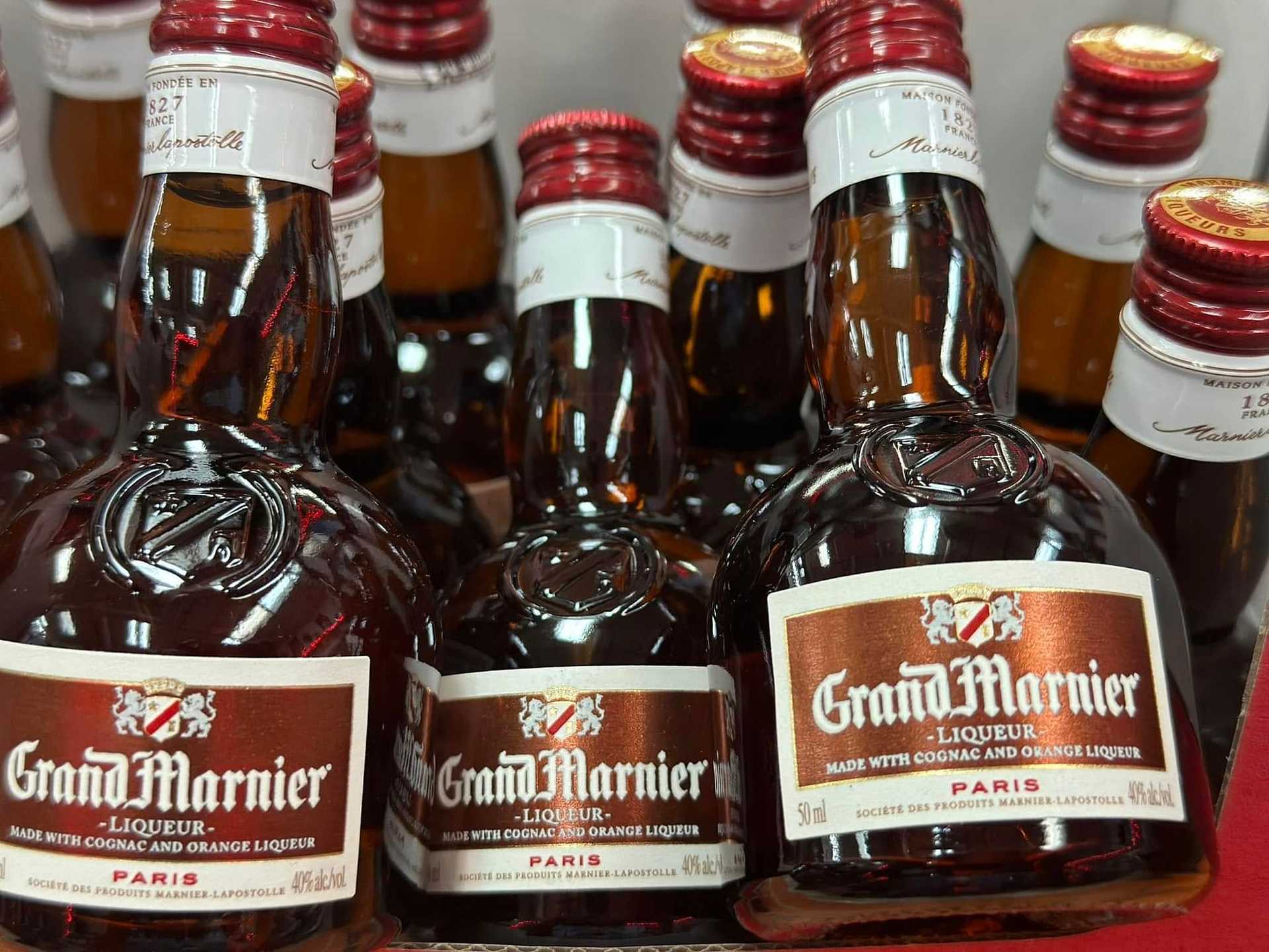 Bottles of Grand Marnier liqueur arranged on a shelf.